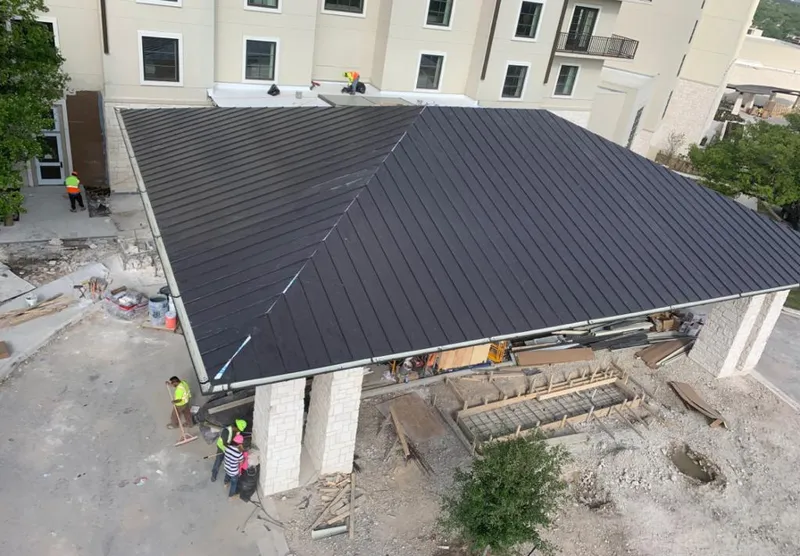 Metal roofing installation team working on a commercial building in Menasha